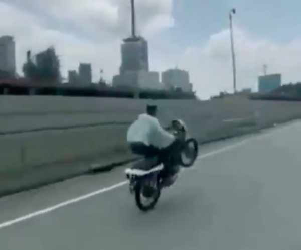 A screenshot of the video showing the suspect performing wheelies on a motorcycle.