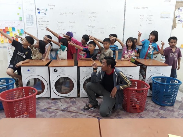 As students have never seen a launderette before, Cikgu Nazmi builds one using cardboard.