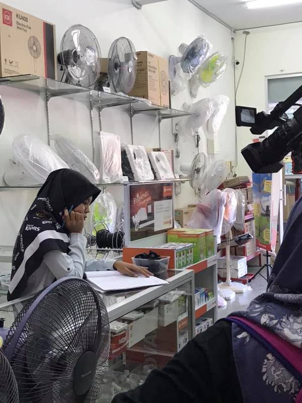 Effa working at her fan shop in Seberang Perai, Penang.