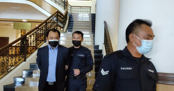 Phillip Among being led by policemen ahead of the hearing at the Kota Kinabalu Magistrate's Court.