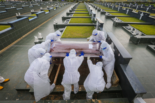 Workers wearing PPEs bury a COVID-19 victim at the Christian cemetery in Fairy Park, Klang.