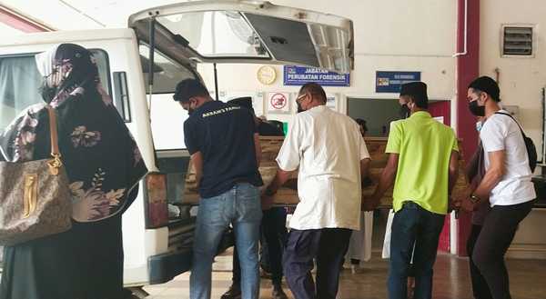 Muhammad Adham Hazim's body being carried into the hearse at the Sultanah Nur Zahirah Hospital Forensics Unit.