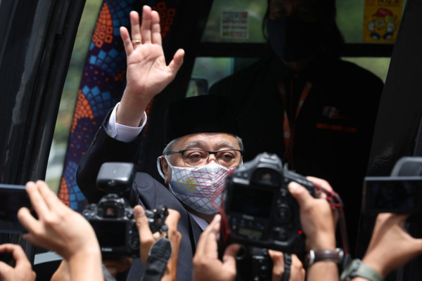 Ismail waving to reporters before departing for a meeting with the Agong on 19 August.