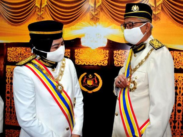 Ismail speaking to former higher education minister Datuk Seri Dr Noraini Ahmad (left) after they were conferred with royal titles on 31 October 2020.