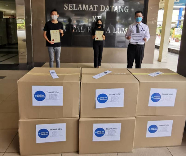 Two of Feed Malaysia's co-founders, Jun Wei Au (left) and Karishma Menon (centre), handing over free face shields to a representative from Kuala Lumpur Hospital last year.