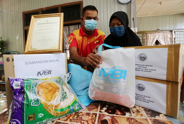 Raduan and his mother looking at the necessities they received during the visit.