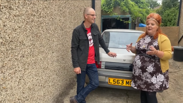 Matt (left) and Steph talking in front of the Proton Saga.