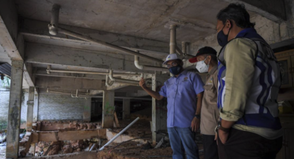 Takiyuddin (left) while visiting an affected home with the Department of Minerals and Geosciences.