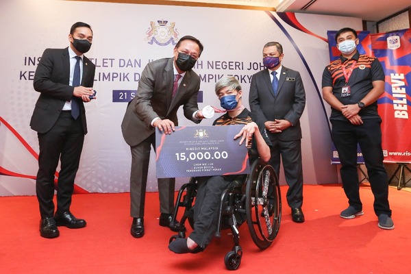 Datuk Hasni Mohammad presents a mock cheque to Chew Wei Lun.