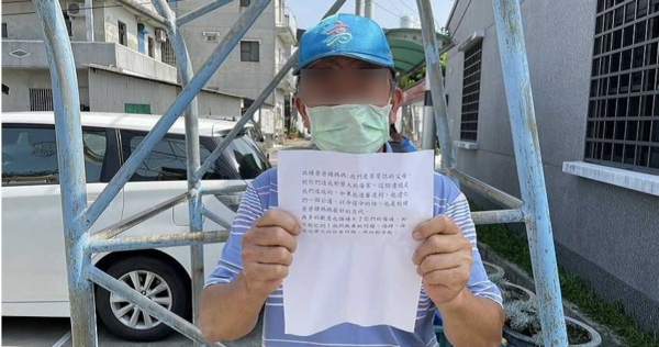 A district head holding up Liang's parents' apology letter.