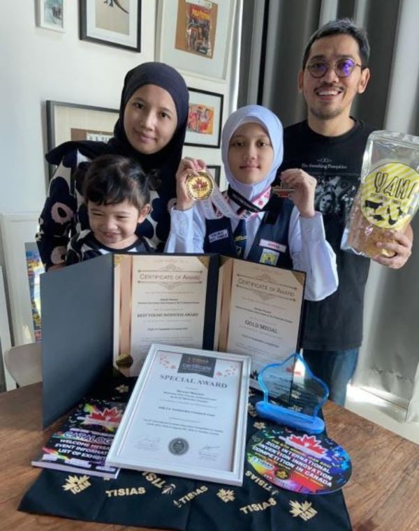 Maryam Muzamir with her family showing the medals and certificates she won at iCAN 2021 on 28 August.