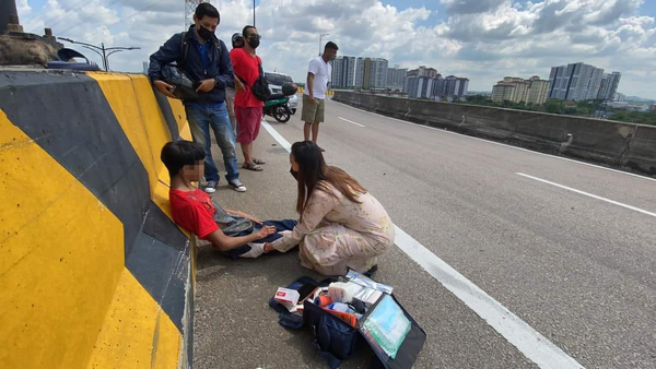 Emergency responder giving first aid to the younger brother.