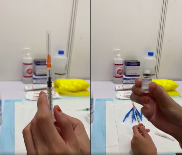 The health worker showing a filled syringe and the vaccine vial.