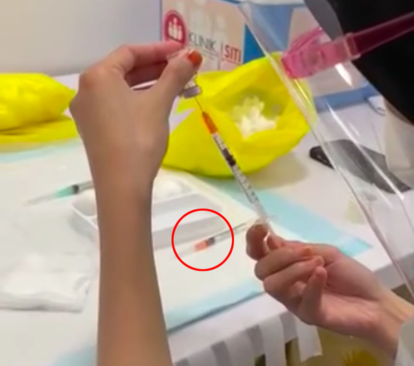 The empty syringe can be visible during the start of the video when the health worker is seen filling a syringe with the vaccine.