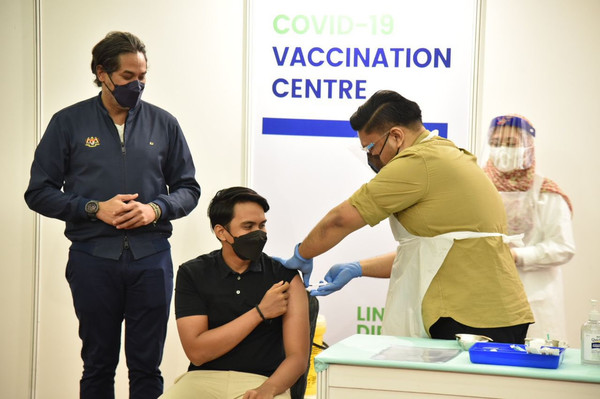 Khairy Jamaluddin overlooks as 20-year-old Mohd Haidhar receives the last vaccine dose at WTCKL during the closing ceremony.