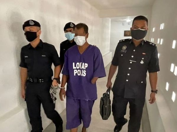 The accused is being escorted at the Kota Bharu Sessions Court in Kelantan today, 10 October.