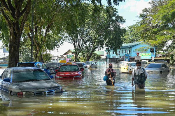 People wading in floodwaters in Shah Alam, Selangor.