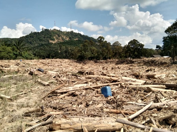 A photo taken by Kampung Sri Telemong community members of the timber debris and rubbish covering the village after the flash flood.