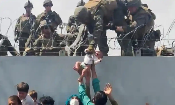 Two-month-old Sohail Ahmadi being handed to a soldier standing on a wall in Kabul, Afghanistan on 19 August.