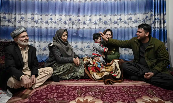 Grandfather Mohammad Qasem Razawi (left) and taxi-driver Hamid Safi (right) as the latter pats Sohail on the head.