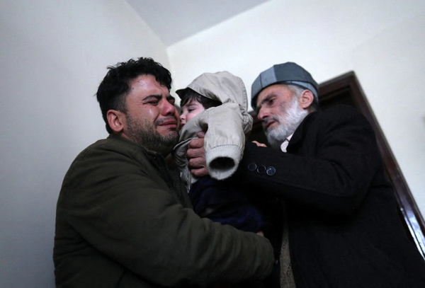 Hamid Safi (left) was crying when baby Sohail was handed to grandfather Mohammad Qasem Razawi (right).