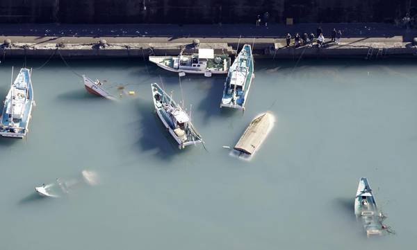 Ships are seen capsized at a port in Muroto, Kochi Prefecture, on Sunday.