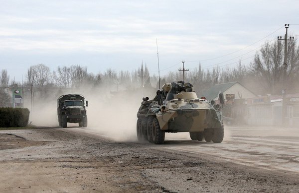 Military vehicles drive along a street after Putin authorised a military operation in eastern Ukraine.