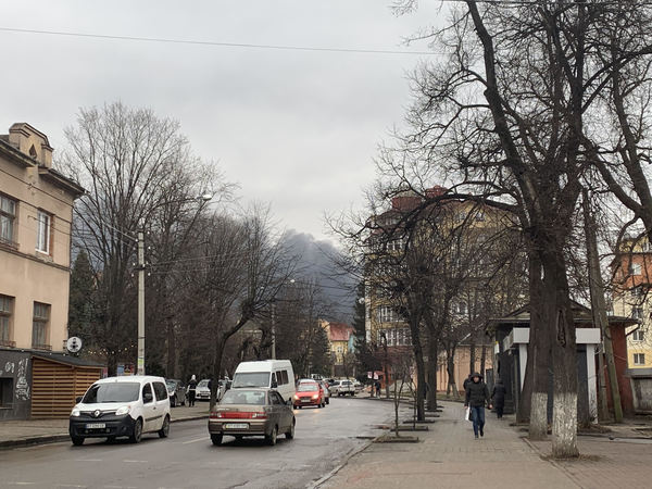 Light traffic is seen in one of the streets in Ivano-Frankivsk as smoke raises from the explosion.