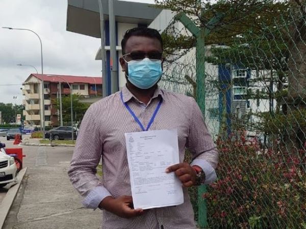 S Dayalan shows a police report on the fraudulent sale of VTL tickets bought by Malaysians in Singapore at the Johor Bahru Selatan district police headquarters.