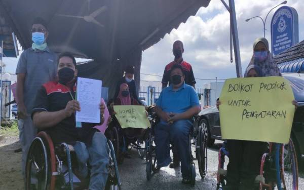 POKUAT president Fakruddin Zakaria (left) and his members at the Kuala Terengganu district police headquarters (IPD) lodge a police report against Wan Nor Baizura.