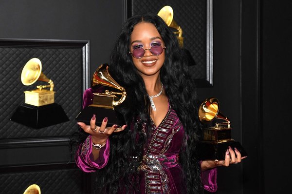 H.E.R. posing with her Best R&B Song and Song of The Year awards at the 63rd Annual GRAMMY Awards in 2021.