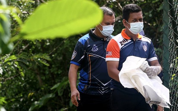 Police retrieving the skeletal remains of Hasnan Hasrul Izwan in Taman Bukit Zamrud on 7 April.