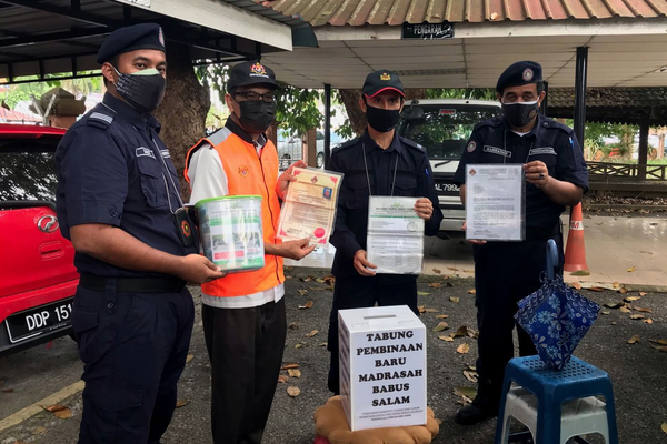 State JKM Enforcement Division assistant director Mohamad Md Nor (second from the left) showing props used by beggars in Kelantan.